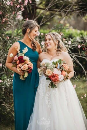 Gledswood Wedding Photo - the bride stands laughing with her bridesmaid