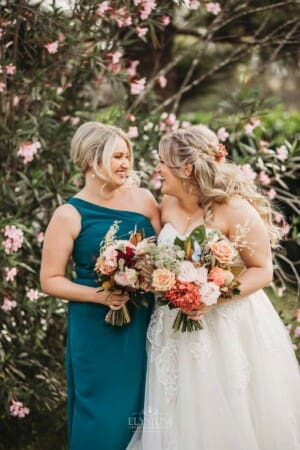 Gledswood Wedding Photo - the bride stands laughing with her bridesmaid