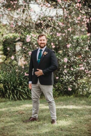 Gledswood Wedding Photo - the groom poses on the lawn at sunset