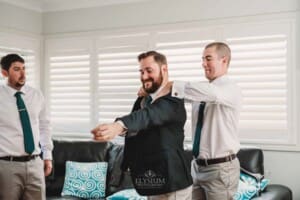 Gledswood Wedding Photo - groomsman helps the groom with his tie