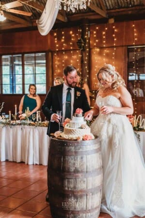 Gledswood Wedding Photo - bride and groom cut their wedding cheese cake