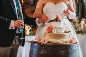 Gledswood Wedding Photo - bride and groom cut their wedding cheese cake