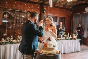 Gledswood Wedding Photo - bride and groom toast after cutting the cake