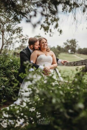 Gledswood Wedding Photo - bride and groom hug at a farm gate