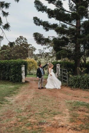 Gledswood Wedding Photo - bride and groom practice their first dance in a dirt road