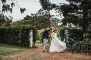 Gledswood Wedding Photo - bride and groom practice their first dance in a dirt road