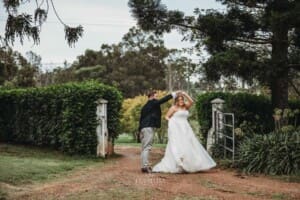 Gledswood Wedding Photo - bride and groom practice their first dance in a dirt road