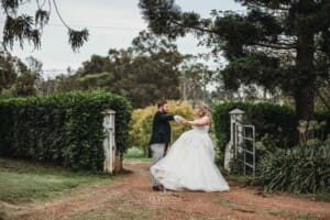 Gledswood Wedding Photo - bride and groom practice their first dance in a dirt road