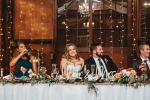 Gledswood Wedding Photo - bride and groom smile listening to the speeches