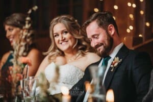 Gledswood Wedding Photo - bride smiles as the groom's father makes his speech
