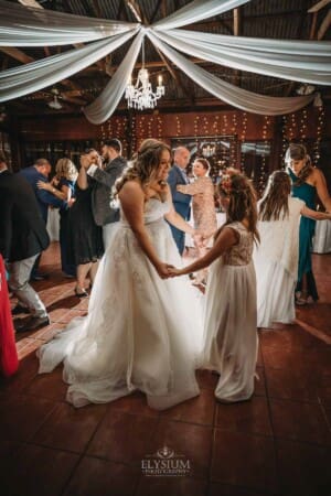 Gledswood Wedding Photo - the bride dances with a flower girl during the reception