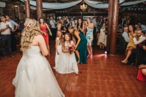 Gledswood Wedding Photo - a flower girl catches the brides bouquet