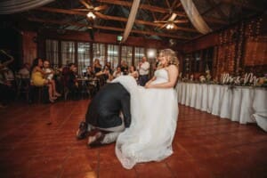 Gledswood Wedding Photo - the groom removes the brides garter