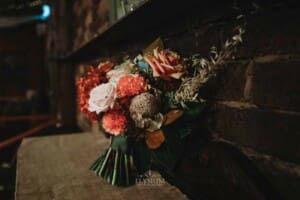Gledswood Wedding Photo - brides floral bouquet sits on a rustic table