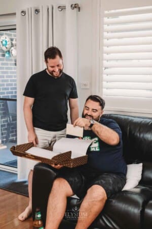 Gledswood Wedding Photo - Groomsman opens a gift from the groom