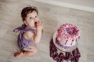 Cake Smash Session - baby girl tastes her pink first birthday cake