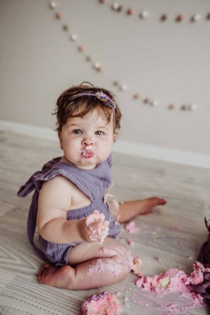 Cake Smash Session - baby girl has a mouthful of pink icing
