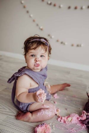 Cake Smash Session - baby girl has a mouthful of pink icing