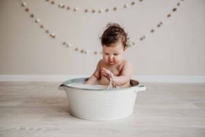 Cake Smash Session - baby girl splashes in a tub after smashing her cake