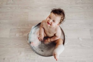 Cake Smash Session - baby girl smiles as she enjoys a bubble bath