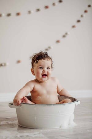 Cake Smash Session - baby girl sits in a bath tub after her cake smash