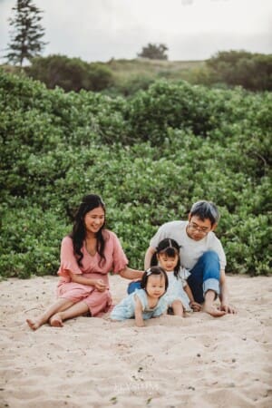 Family Photographer - parents play in the sand with their little girls
