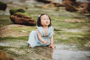 Family Photographer - a little girl plays with water in a beach rock pool