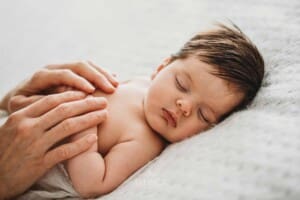 Baby Photography - a mother holds her sleeping newborn's hands