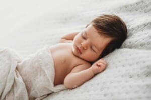 Baby Photography - newborn girl sleeping on a white blanket