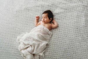 Baby Photography - newborn girl sleeping on a white blanket