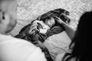 Newborn Photograph - parents admire their baby boy as he sleeps