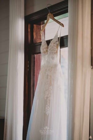 Burnham Grove Wedding - brides wedding gown hangs in a doorway