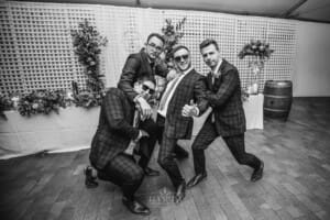 Burnham Grove Wedding - the groom strikes a pose with the groomsmen