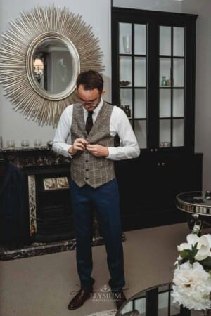 Burnham Grove Wedding - the groom doing up his vest buttons