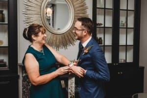 Burnham Grove Wedding - groom helps his mother with her flower corsage