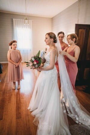 Burnham Grove Wedding - bridesmaids attach the brides veil before the ceremony