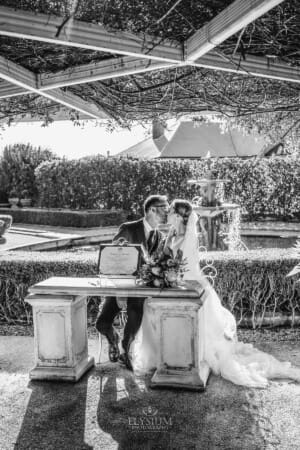 Burnham Grove Wedding - newlyweds share a kiss before signing the certificate