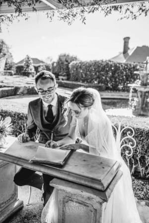 Burnham Grove Wedding - a bride signs the marriage certificate