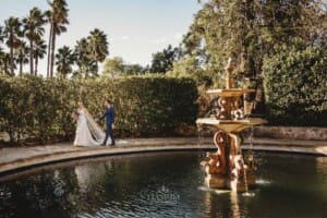 Burnham Grove Wedding - bride and groom walk around the fountain