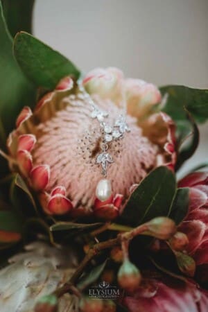 Burnham Grove Wedding - brides necklace drapes over her bouquet