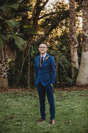 Burnham Grove Wedding - groom stands in the Palm Grove for a portrait