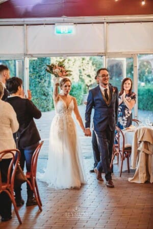 Burnham Grove Wedding - the bride and groom enter their wedding reception