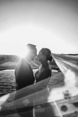 Burnham Grove Wedding - newlyweds cuddle as the brides veil sweeps around them