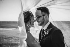 Burnham Grove Wedding - bride and groom hug standing under the bridal veil