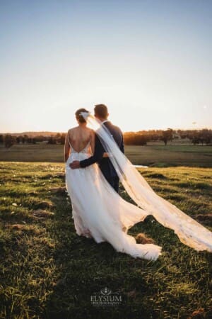 Burnham Grove Wedding - bride and groom hug as they watch the sun setting