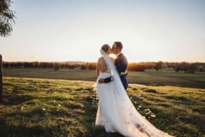 Burnham Grove Wedding - bride and groom kiss as they watch the sun setting