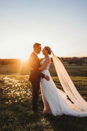 Burnham Grove Wedding - bride and groom hug as the sun sets behind them