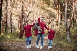 3 brothers swing their little sister up in the air