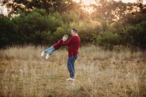 A dad spins around while holding his son