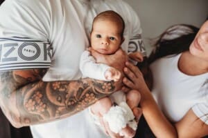 Newborn Photograph - parents hold their tiny baby boy between them